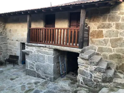 a balcony on the side of a stone building at Casa Lisboana in Pontevedra