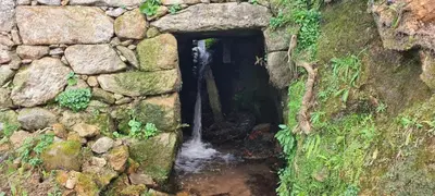 a small waterfall in a stone wall with a creek at Casa Lisboana in Pontevedra