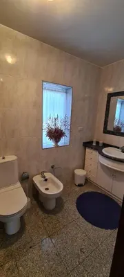 a bathroom with a toilet and a sink and a window at Casa Lisboana in Pontevedra