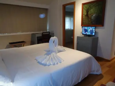 a white bed with a towel on top of it at Hotel Villa De Betanzos in Betanzos