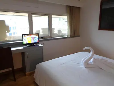 a bedroom with a white bed and a computer on a desk at Hotel Villa De Betanzos in Betanzos