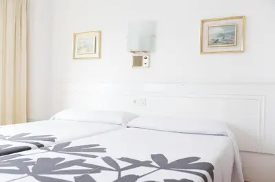 a white bed with a black and white blanket on it at Rey Fernando in Santiago de Compostela