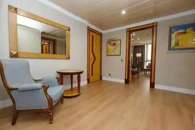 a living room with a chair and a mirror at Oca Puerta del Camino Hotel in Santiago de Compostela