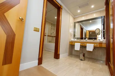 a bathroom with a sink and a mirror and a tub at Oca Puerta del Camino Hotel in Santiago de Compostela