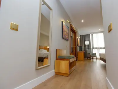 a hotel room with a bed and a mirror at Oca Puerta del Camino Hotel in Santiago de Compostela