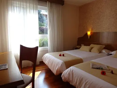 a hotel room with two beds and a window at Hotel El Pescador in Perillo