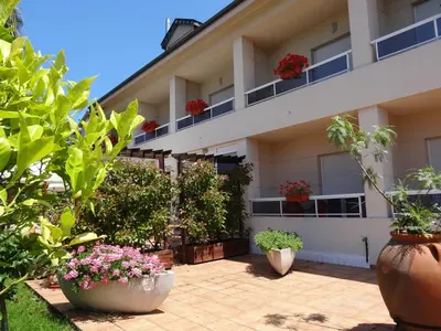 a building with potted plants in front of it at Hotel El Pescador in Perillo