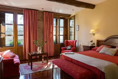 a hotel room with a red bed and a chair at Hotel Rua Villar in Santiago de Compostela
