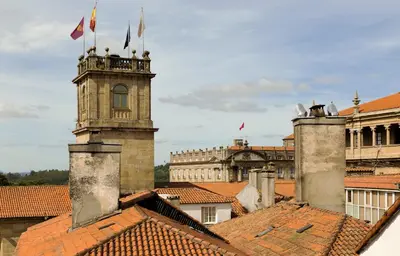 a building with a clock tower on top of roofs at Hotel Rua Villar in Santiago de Compostela