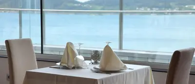 a table with napkins on it with a view of the water at Apartamentos Las Sirenas in Viveiro