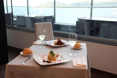 a table with two plates of food and two glasses of wine at Apartamentos Las Sirenas in Viveiro