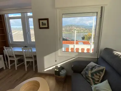 a living room with a couch and a large window at Casa Da Ponte By Oktheway in Puentedeume