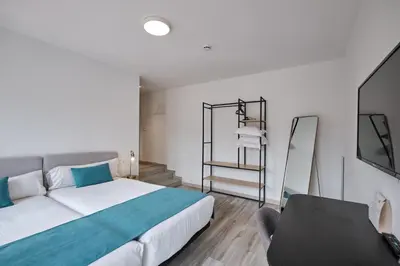 a bedroom with a bed and a chair in it at Hotel Pombal Rooms in Santiago de Compostela