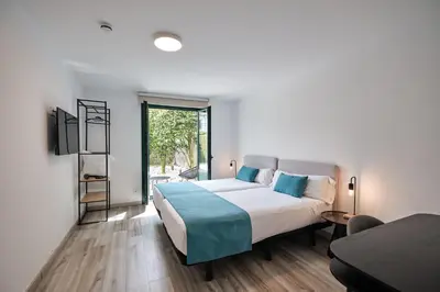 a bedroom with a large bed and a window at Hotel Pombal Rooms in Santiago de Compostela