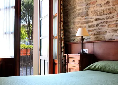 a bedroom with a bed and a brick wall at San Clemente by Pousadas de Compostela in Santiago de Compostela