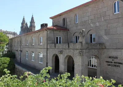 an old stone building with a clock tower in the background at San Clemente by Pousadas de Compostela in Santiago de Compostela