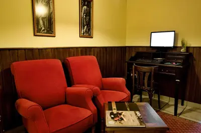 a waiting room with two chairs and a piano at San Clemente by Pousadas de Compostela in Santiago de Compostela