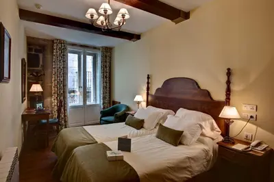 a bedroom with a large bed with a wooden headboard at Airas Nunes by Pousadas de Compostela in Santiago de Compostela