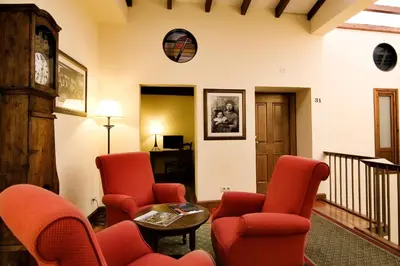 a living room with red chairs and a table at Airas Nunes by Pousadas de Compostela in Santiago de Compostela