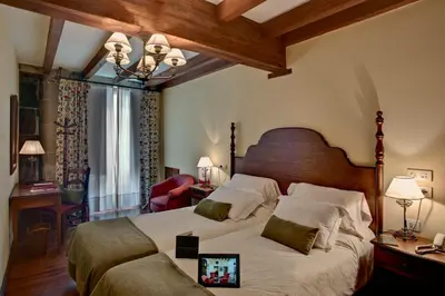 a bedroom with a large bed with a wooden headboard at Airas Nunes by Pousadas de Compostela in Santiago de Compostela