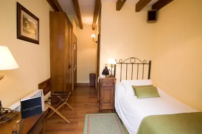a bedroom with a bed and a desk with a lamp at Airas Nunes by Pousadas de Compostela in Santiago de Compostela