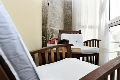 a room with two chairs and a table with white pillows at Airas Nunes by Pousadas de Compostela in Santiago de Compostela