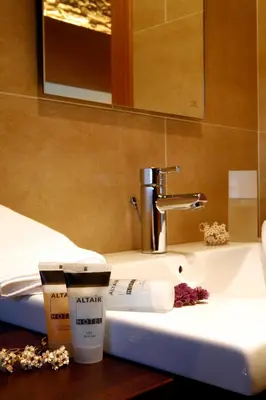 a bathroom sink with a toothbrush and a cup of coffee at Hotel Altaïr in Santiago de Compostela