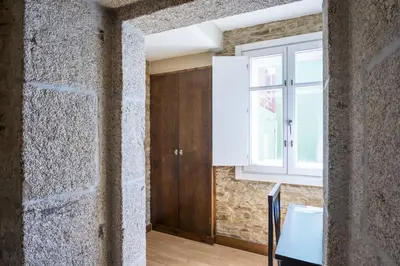 a room with a stone wall and a window at Hotel Alda Avenida in Santiago de Compostela