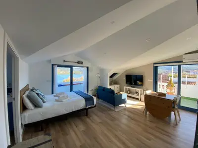 a bedroom with a large bed and a living room at O Faiado by Oktheway in Puentedeume