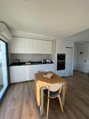 a kitchen with white cabinets and a wooden table at O Faiado by Oktheway in Puentedeume