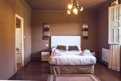 a bedroom with a bed and a chandelier at Houmi A Ponte in Boimorto