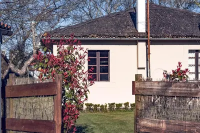 a white house with a wooden fence in front of it at Houmi A Ponte in Boimorto