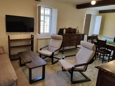 a living room with chairs and a flat screen tv at Casa Carmiña: Casa para pequeños grupos en el corazón de Galicia in O Irixo