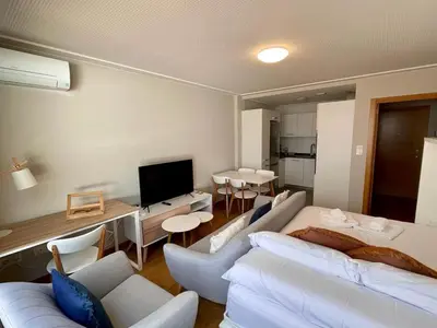 a living room with white furniture and a television at Estudio céntrico 2 con terraza y parking privado in Ourense