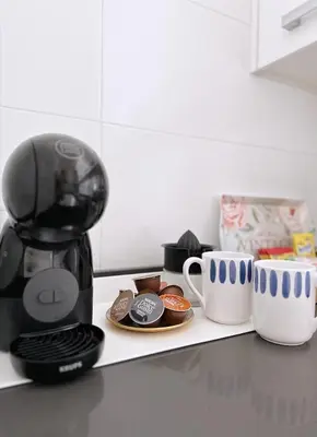 a coffee maker and cups on a kitchen counter at Estudio céntrico 2 con terraza y parking privado in Ourense