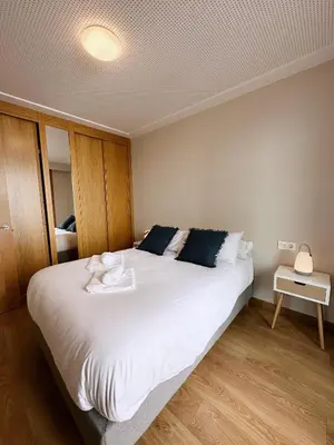 a bedroom with a large bed with white sheets at Estudio céntrico 2 con terraza y parking privado in Ourense