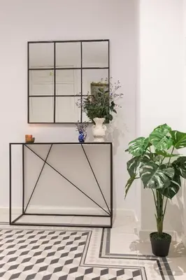 a mirror on a dresser in a room with a plant at Zafiro Flat by Serendipia Turismo in Santiago de Compostela