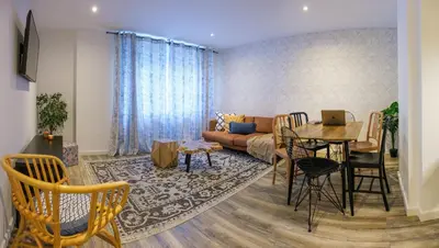 a living room with a table and a couch at Zafiro Flat by Serendipia Turismo in Santiago de Compostela