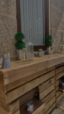 a wooden table with potted plants and a window at Casa Escuela Trasmiras, Casa dos Mestres in Trasmiras