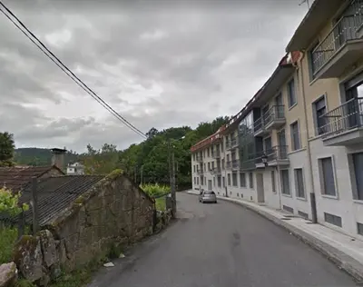 an empty street with buildings and a car on the road at Ático Alquiler Mondaríz Paraiso del agua. Vistas espectaculares in Mondariz