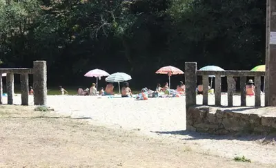 a group of people laying on the beach with umbrellas at Ático Alquiler Mondaríz Paraiso del agua. Vistas espectaculares in Mondariz