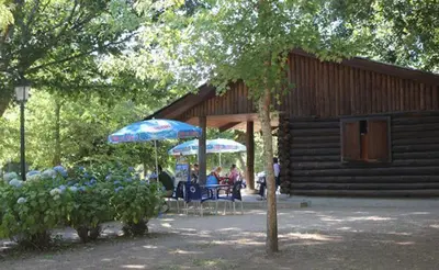a group of people sitting under umbrellas outside a cabin at Ático Alquiler Mondaríz Paraiso del agua. Vistas espectaculares in Mondariz