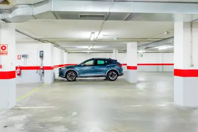 a blue car parked in a parking lot at Ponferrada Plaza in Ponferrada