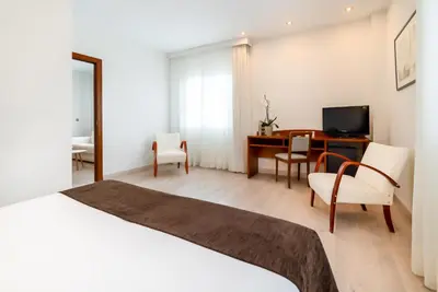 a hotel room with a bed and a desk and a television at Ponferrada Plaza in Ponferrada