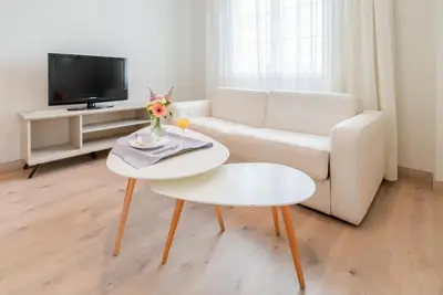 a living room with a white couch and a table at Ponferrada Plaza in Ponferrada