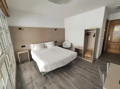 a bedroom with a large bed with wooden cabinets at Hotel Hórreo by Bossh! Hotels in Santiago de Compostela