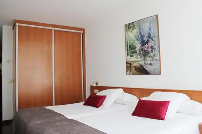 a bedroom with a bed with white sheets and red pillows at Hotel Hórreo by Bossh! Hotels in Santiago de Compostela