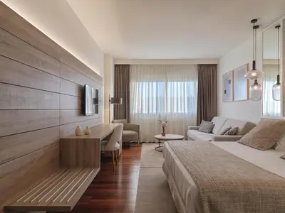 a hotel room with a bed and a living room at Aparthotel Attica21 As Galeras in Bastiagueiro