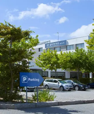 a hotel room with a bedroom with a desk and a bed at Aparthotel Attica21 As Galeras in Bastiagueiro