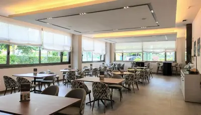 a restaurant with tables and chairs in a room at Aparthotel Attica21 As Galeras in Bastiagueiro